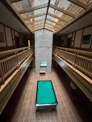 an empty hall with a green table in the middle at PIRIN GOLF DELUXE PRIVATE STUDIO GABBY ground floor in Bansko