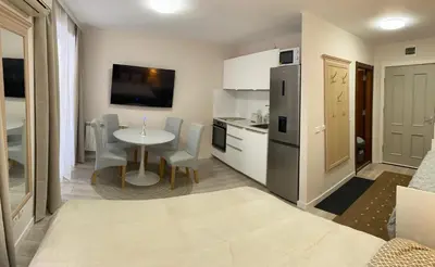 a kitchen and dining room with a table and a refrigerator at Studio 4, 4min walk to slope at Predela2 Bansko in Bansko