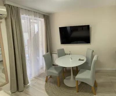 a dining room with a white table and chairs at Studio 4, 4min walk to slope at Predela2 Bansko in Bansko