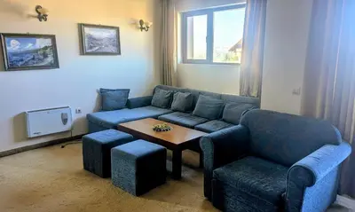 a living room with a blue couch and a table at Mountain view apartment at Emerald Hotel in Bansko