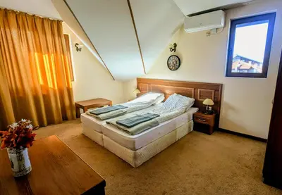 a bedroom with a bed and a table and a clock at Mountain view apartment at Emerald Hotel in Bansko