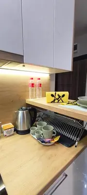 a kitchen counter with bowls and cups on a shelf at VB Residence Vitosha View Apartment in Sofia