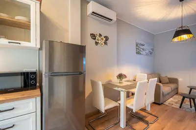 a kitchen and dining room with a table and a refrigerator at The Urban Pulse Stylish Flat in Sofia