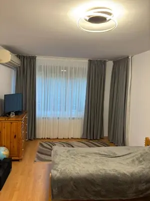 a bedroom with a bed and a large window at Kiryanov's apartment in Sandanski