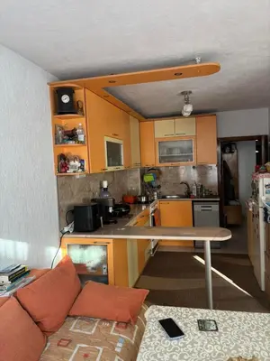 a kitchen with orange cabinets and a table in a room at Kiryanov's apartment in Sandanski