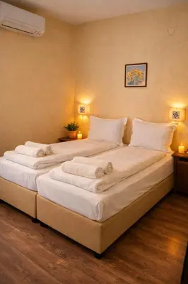 a large white bed in a room with two lamps at Хотел Ривърсайд Анекс in Bansko