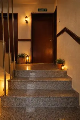 a staircase leading to a door in a building with lights at Хотел Ривърсайд Анекс in Bansko