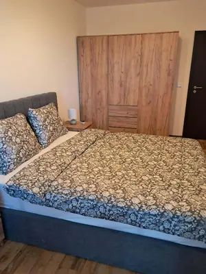 a bedroom with a large bed with a wooden headboard at Apartment Kapina in Pamporovo
