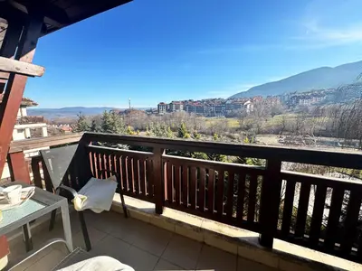 a balcony with a table and a view of the mountains at EMIS Alpine Retreat - Modern & Cozy & Bright in Bansko
