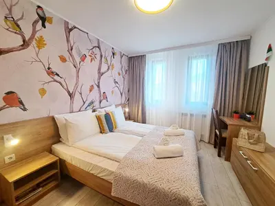 a bedroom with a bed and a wall with birds at EMIS Alpine Retreat - Modern & Cozy & Bright in Bansko