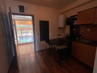 a kitchen with a table and a door with a window at Princeps De Cura Bansko in Bansko