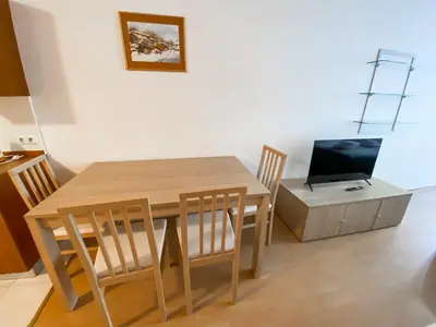a dining room with a wooden table and a television at Private Studio 500m from Gondola in Bansko