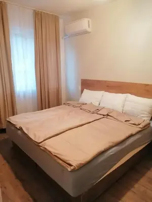 a bed sitting in a room with a window at Апартамент Light blue in Troyan