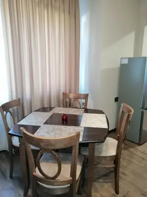 a dining room table and chairs in a room at Апартамент Light blue in Troyan