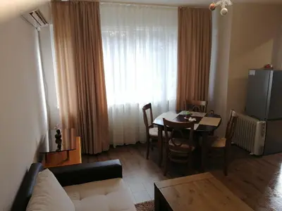 a living room with a couch and a dining room table at Апартамент Light blue in Troyan