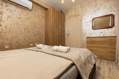 a bedroom with a large bed with two towels at Square Slivnitsa 2BR apt 5 minutes from top center in Plovdiv