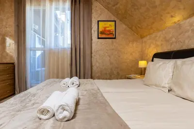 a bedroom with towels on a bed with a window at Square Slivnitsa 2BR apt 5 minutes from top center in Plovdiv