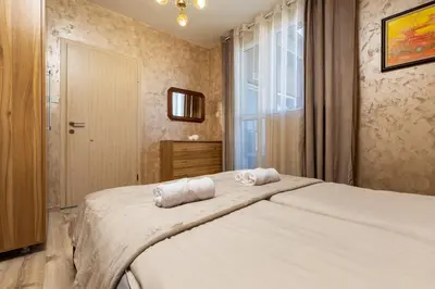 a bedroom with a large bed with two towels on it at Square Slivnitsa 2BR apt 5 minutes from top center in Plovdiv