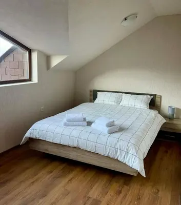 a bedroom with a bed with white sheets and a window at ElGora Studio в Apart Hotel Comfort in Bansko