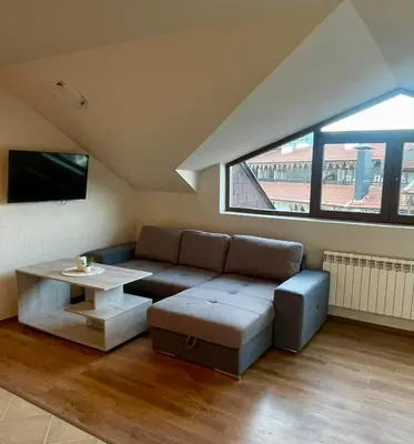 a living room with a couch and a table at ElGora Studio в Apart Hotel Comfort in Bansko
