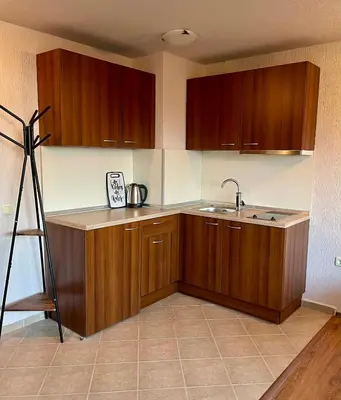 a kitchen with wooden cabinets and a sink at ElGora Studio в Apart Hotel Comfort in Bansko
