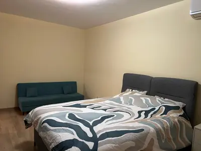 a bedroom with a bed and a blue couch at Flat in Darvenitsa near Church St George the Victorious in Sofia