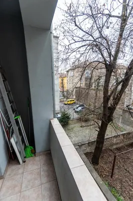 a building with a window with a tree and a street at Gurko Finest in Sofia