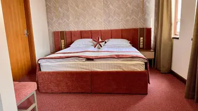 a bedroom with a large bed with a bow on it at Спа Хотел Орфей in Devin