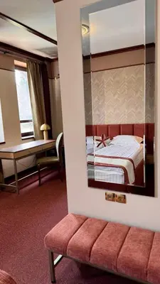 a hotel room with a bed and a mirror at Спа Хотел Орфей in Devin