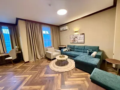 a living room with a green couch and a table at Спа Хотел Орфей in Devin