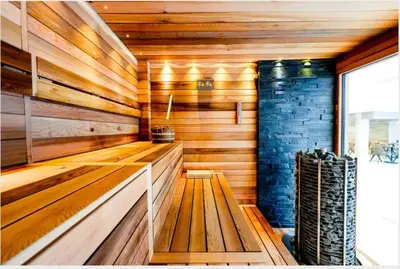 a sauna with wooden walls and a brick wall at Predela 2 Aparthotel Ski & Spa 200m from slopes in Bansko