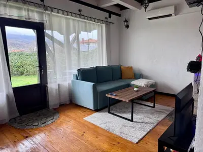 a living room with a blue couch and a table at RhodoNest in Kara Agach