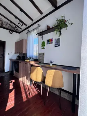 a kitchen with a wooden table and two chairs at RhodoNest in Kara Agach