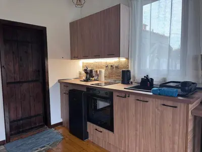 a kitchen with wooden cabinets and a black stove top oven at RhodoNest in Kara Agach