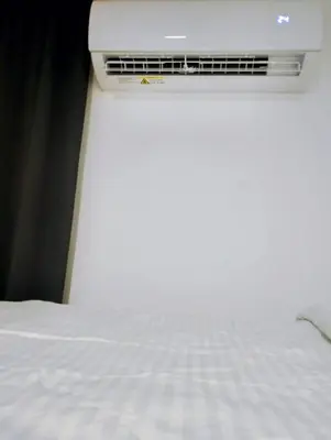 a bed with a white mattress and an air conditioner at GuestHouse1 Karma369 in Plovdiv