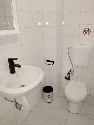 a white bathroom with a toilet and a sink at GuestHouse1 Karma369 in Plovdiv