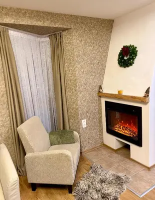 a living room with a chair and a fireplace at Deluxe Apartment 34 Mountain Lodge Pamporovo in Pamporovo