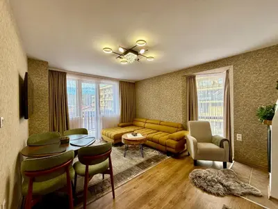 a living room with a couch and a table and chairs at Deluxe Apartment 34 Mountain Lodge Pamporovo in Pamporovo