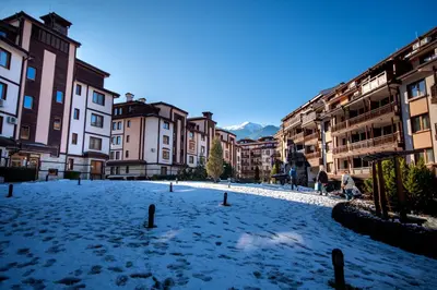 a snow covered street in a city with buildings at Ametist - Comfort by the Gondola Lift in Bansko