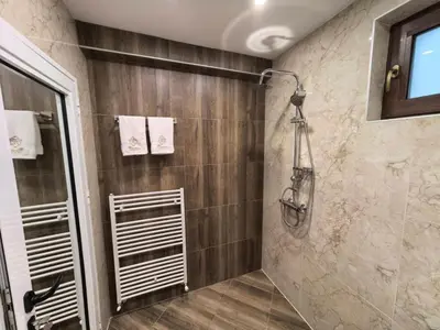a bathroom with a shower with a glass door at Карина - къща за гости in Ognyanovo