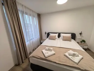 a bedroom with a large bed with towels on it at Карина - къща за гости in Ognyanovo