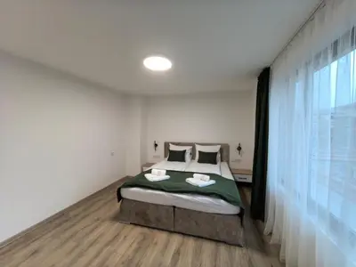 a bedroom with a bed and a large window at Карина - къща за гости in Ognyanovo
