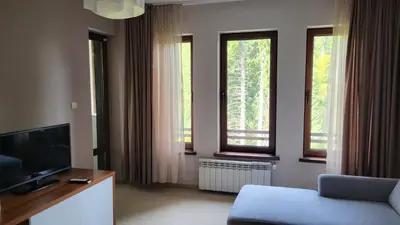 a living room with two windows and a television at Apartments Pamporovo, Green life apartment hotel in Pamporovo