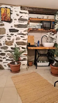 a room with a stone wall with a sink and a table at Rilski Chardak in Sapareva Banya