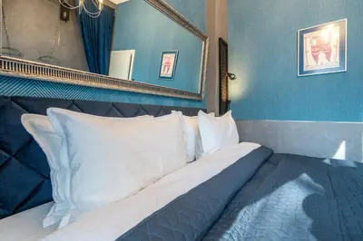 a bedroom with a bed with white pillows and a mirror at NG- apartments in Sofia