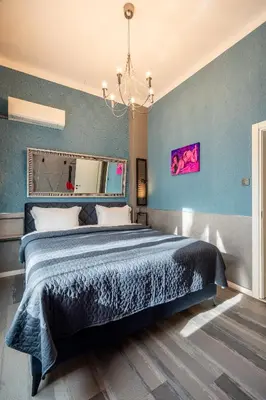 a bedroom with a large bed with blue walls at NG- apartments in Sofia