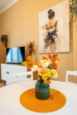 a green vase with flowers on a table at NG- apartments in Sofia