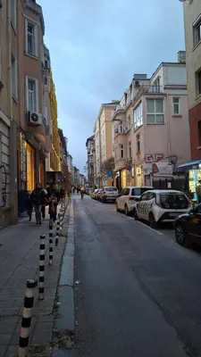 a city street with buildings and people walking down the street at NG- apartments in Sofia