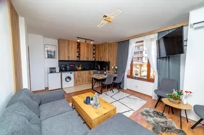 a living room with a couch and a table at Pirin SkiLift Apartment - Cozy & Modern App in Bansko, 100 m to the Gondola in Bansko