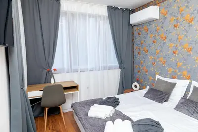 a bedroom with two beds and a desk and a window at Pirin SkiLift Apartment - Cozy & Modern App in Bansko, 100 m to the Gondola in Bansko